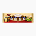 A Lindt Alcohol Specialties Bottles Marc de Champagne chocolate gift box featuring four Lindt chocolate pralines decorated with champagne bottles, surrounded by festive holiday graphics on a light gray background.