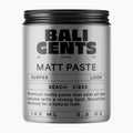A silver cylindrical jar of Bali Gents Matt Paste with a black screw-on lid, shown on a plain light gray background. The label features black text including 'BALI GENTS', 'MATT PASTE', 'SURFER LOOK', and 'BEACH VIBES'.