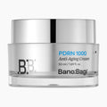 Bano:Bagi PDRN 1000 Anti-Aging Cream in a clear glass jar with a reflective silver lid, on a light gray background.