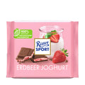 Packaging of Ritter Sport Strawberry Yogurt milk chocolate bar, 100 g, showing the chocolate bar, a glass of yogurt, and a strawberry, against a pink background.