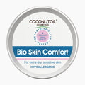 A round silver metal tin of Coconutoil Cosmetics Bio Skin Comfort hypoallergenic body butter, featuring a white label with blue and pink accents, on a light gray background.