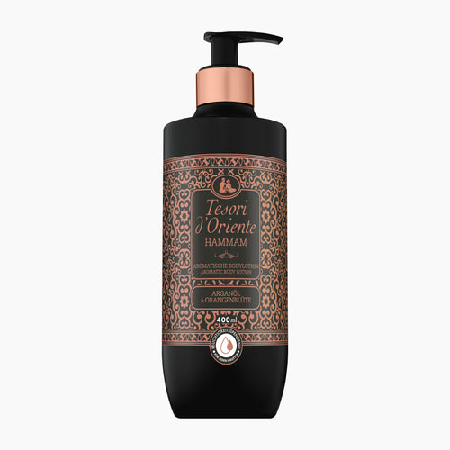 A 400ml pump bottle of Tesori d'Oriente Hammam body lotion. The bottle is matte black with a metallic rose gold collar and a detailed brown and gold ornate label.