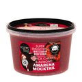 A clear plastic tub of Organic Shop Black Cherry & Almond Amarena Mocktail body scrub, showing the deep reddish-purple scrub inside, with a red and black label and a black lid.