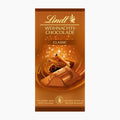 Lindt Christmas Chocolate Classic milk chocolate bar packaging, featuring a warm brown design with gold lettering and an illustration of a chocolate-covered almond with cinnamon.
