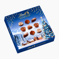 Lindt Christmas Magic Mini Pralines chocolate box with a winter Christmas scene illustration, featuring assorted mini chocolates on a light gray background.