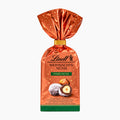 A package of Lindt Christmas Nuts Hazelnut in a metallic copper-orange bag with a gold foil top and green base, shown on a plain white background.