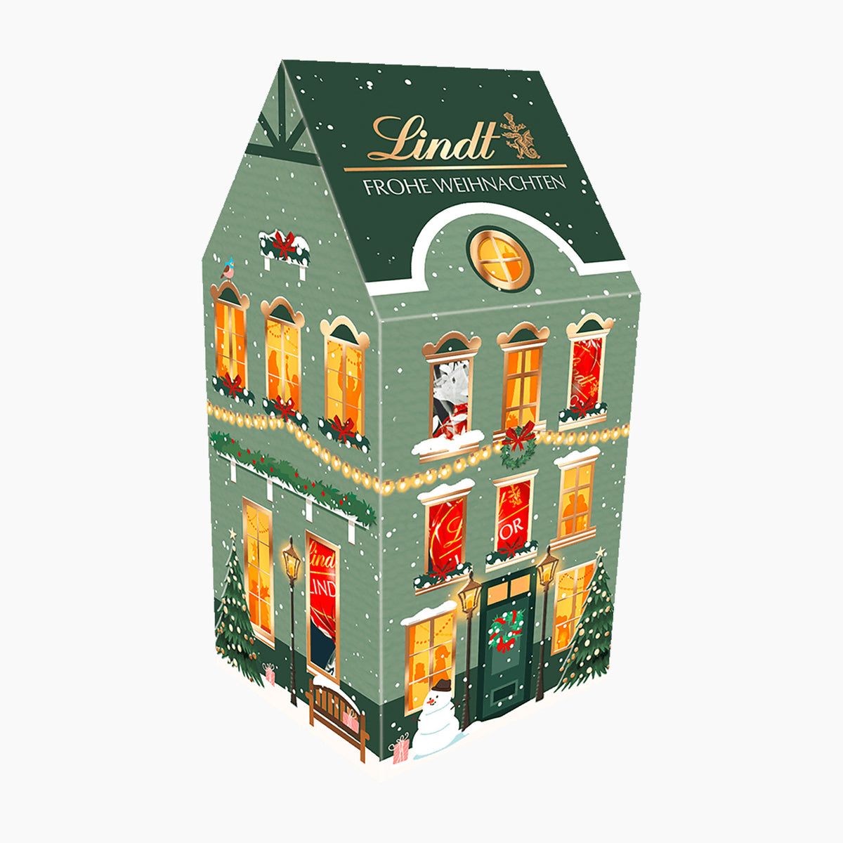 A Lindt Christmas Small House chocolate pralines box with a green facade, warm glowing windows, and festive decorations, shown on a plain white background.