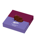 A gift box of Milka Delicate Hearts Dark Milk Chocolate Hearts, with a heart-shaped chocolate piece on the cover, against a purple background.