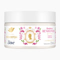 A white jar of Dove Bridgerton Raspberry Rendezvous body scrub, featuring a decorative label with gold, pink, and green accents, on a light gray background.