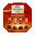 A red octagonal box of Trumpf Edle Tropfen in Nuss Obstliköre Fruit Liqueur Pralines, featuring illustrations of four different flavored chocolate desserts (cherry, apricot, blackcurrant, and peach) on a white background.