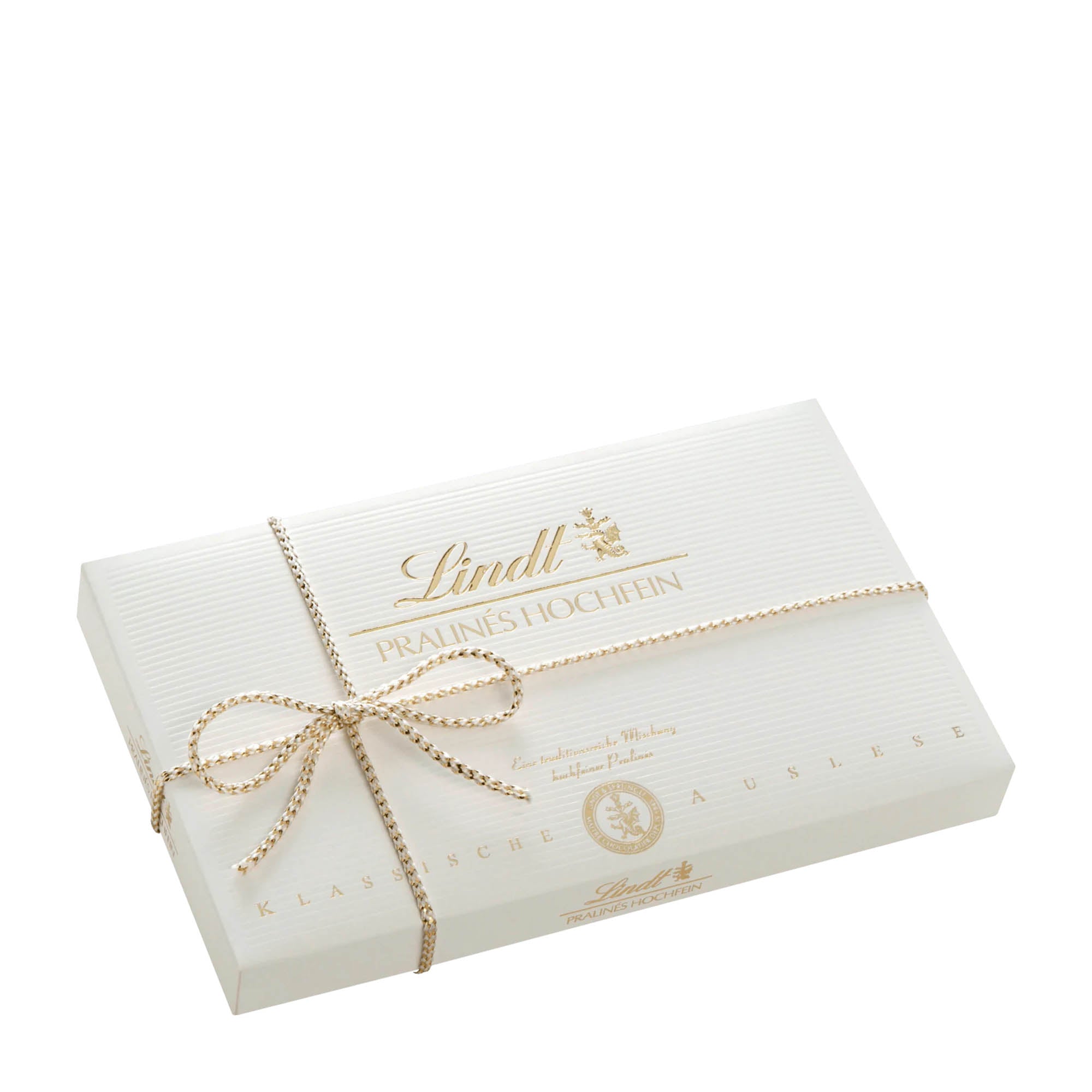 A Lindt gift box of fine pralines, with a white exterior and a golden ribbon bow.