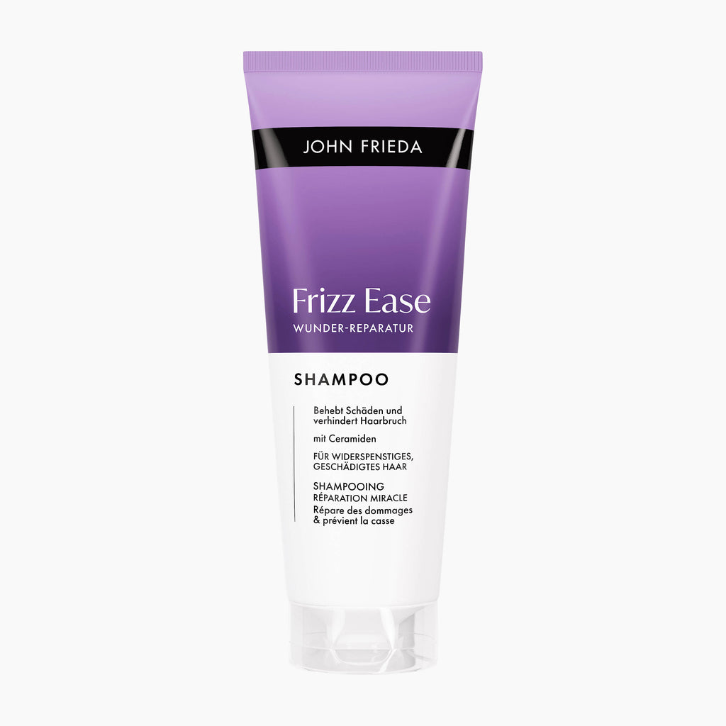A tube of John Frieda Frizz Ease Miracle Repair Shampoo on a light gray background. The tube is purple and white with black text.