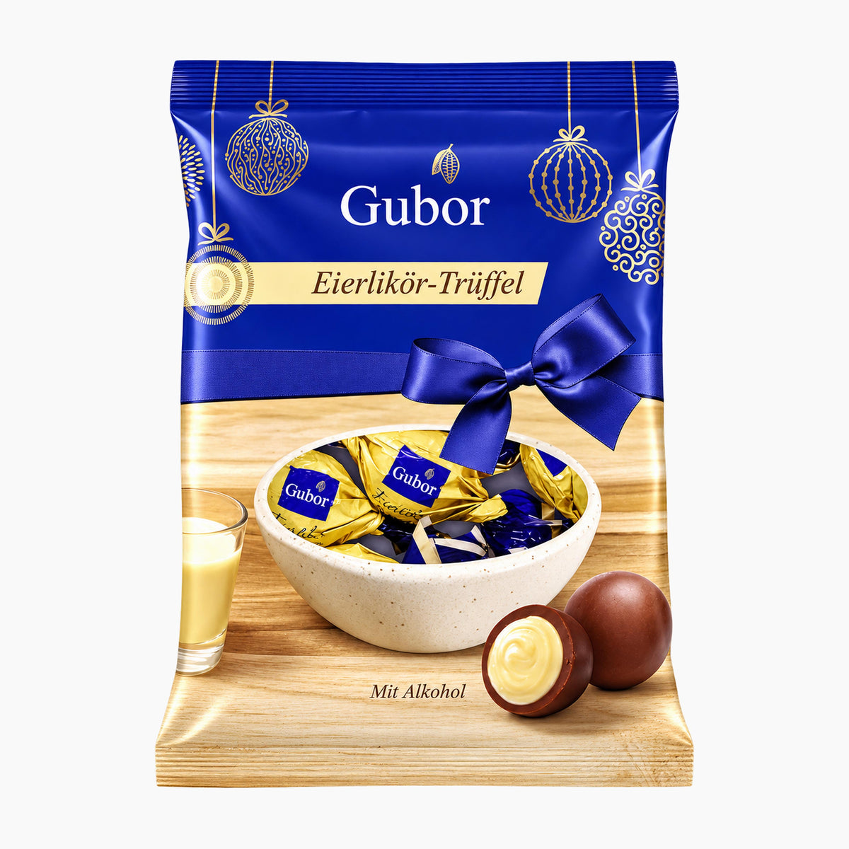 A bag of Riegelein Gubor Eierlikör-Trüffel Egg Liqueur Truffles milk chocolate truffles, featuring a festive blue and gold holiday design with a bowl of wrapped chocolates and chocolate pieces on a light wood background.