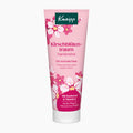 A pink squeeze tube of Kneipp Cherry Blossom Dream Hand Cream with white and pink floral illustrations, set against a plain light gray background.