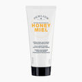 A 100 ml squeeze tube of Perlier Honey Miel Daily Moisturizing Hand Cream. The tube is white with a black cap, featuring yellow and gray text on the front, set against a clean white background.