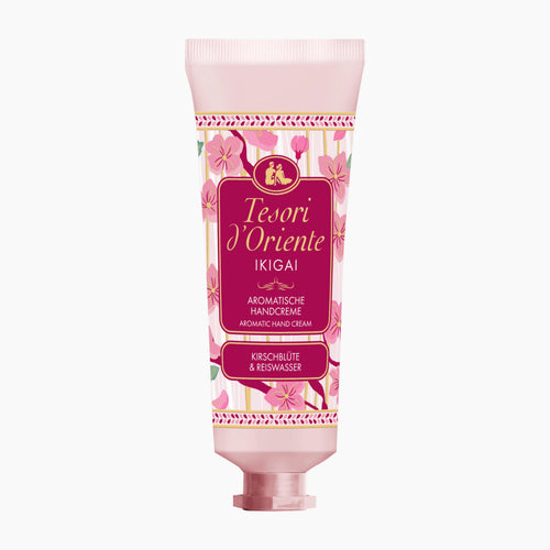 A pink squeeze tube of Tesori d'Oriente Ikigai Aromatic Hand Cream, featuring a floral pattern and a prominent magenta label, set against a plain white background.