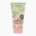 Jean & Len Express Chamomile & Olive Oil Hand Cream tube with a light green background decorated with white daisies, yellow centers, and a pink lower section on a light gray background.
