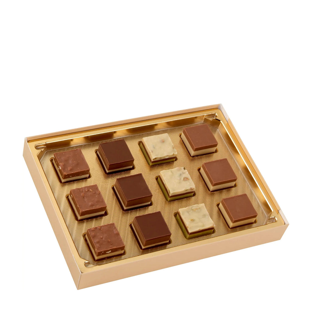 Gold box with layered nougat pralines on a white background