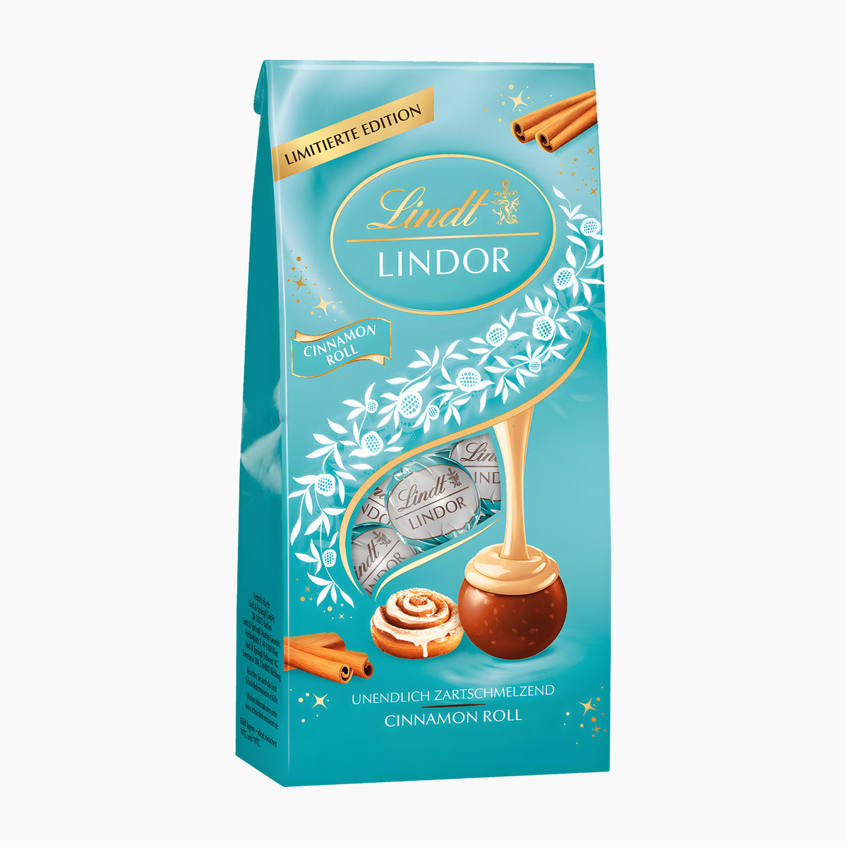 A package of Lindt Lindor Cinnamon Roll limited edition chocolate pralines, featuring a turquoise blue bag with gold and white decorative elements, a large chocolate cinnamon roll, and smaller wrapped chocolates.