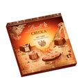A box of Lindt Creola pralines with various chocolate pieces displayed on the front, indicating different flavors such as 'Xoya,' 'Cacautl,' 'Yuca,' and 'Ek Chuah.'.