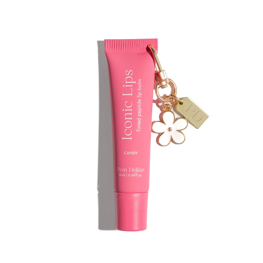 Pink lip balm tube with a charm on a white background