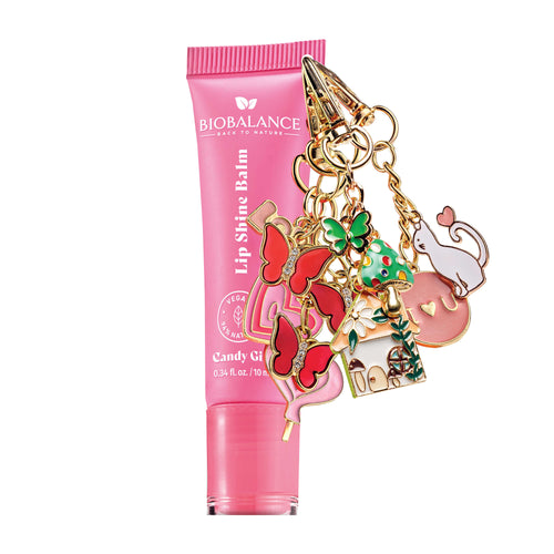 Pink lip balm with colorful charms on a white background