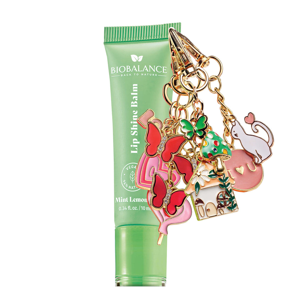 Lip shine balm with colorful charm on a white background