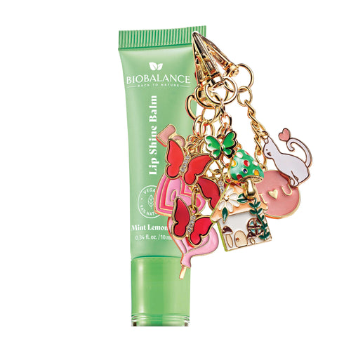 Lip shine balm with colorful charm on a white background