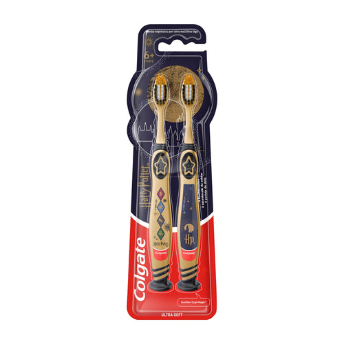 Two Colgate Harry Potter themed manual toothbrushes in their original blister packaging, featuring gold and dark blue handles with star and diamond designs.