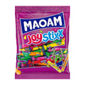 A package of Maoam Joystixx chewy candy featuring multiple colorful candy sticks with a cherry on top, against a pink background.