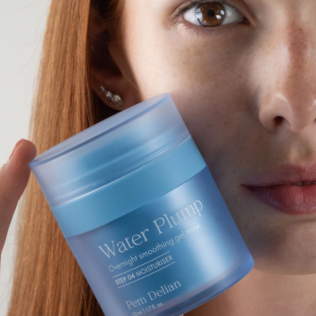 Woman holding a blue jar of 'Water Plump' gel mask close to her face.