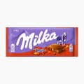 A 90g bar of Milka Daim chocolate in its original packaging, featuring a purple and red wrapper with the brand name 'Milka' in white script, a cow illustration, and a chocolate bar graphic.
