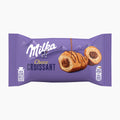 A purple package of Milka Choco Croissant, featuring an illustration of a chocolate-filled croissant with drizzled chocolate on a light gray background.