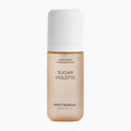 A bottle of Misty Monday Sugar Violette hair and body fragrance mist, featuring a warm beige body and a white cap, centered on a light gray background.