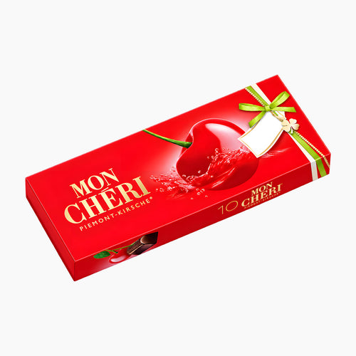 A red Mon Cheri chocolate pralines package with a glossy red cherry graphic, gold lettering, and a green ribbon illustration, shown on a plain light gray background.
