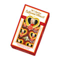 A box of Reber W. Amadeus Mozart Herz'l heart pralines, with visible individually wrapped heart-shaped pralines inside.