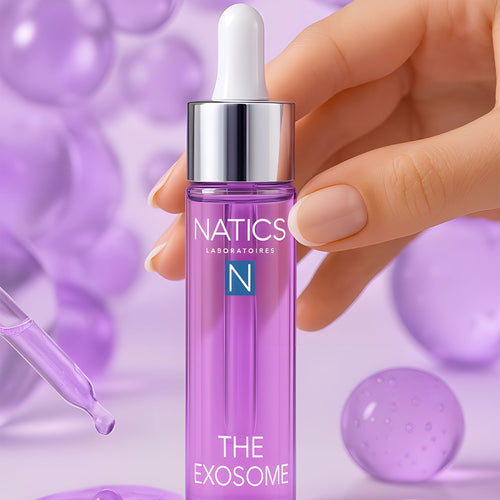 Hand holding a Natics skincare dropper bottle with a purple background