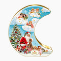A crescent-shaped Heidel Christmas Nostalgia Crescent Moon Gift Tin with a gold-trimmed edge, featuring vintage-style illustrations of Santa Claus, angels, children, a snowy Christmas tree, and musical notes on a light blue sky background. The brand name 'Confiserie HEIDEL' is visible in the lower center.