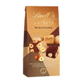 A package of Lindt Nuxor Mix pralines, featuring images of white, milk, and dark chocolate pralines with whole hazelnuts, and text describing the product.