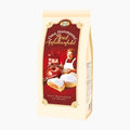 A package of Oma Hartmanns Bratapfelkonfekt Mini Baked Apple Confections, shown on a clean white background. The packaging is cream-colored with a large red front label featuring an illustration of a woman, an apple, and two baked pastries.