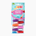 A 7-piece set of Oopsi fruit-flavored candy lipsticks in a clear plastic blister pack with a light blue and pink cardboard header. The lipsticks come in purple, red, orange, and pink colors.
