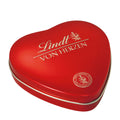 Red heart-shaped Lindt Pralines metal tin on a white background