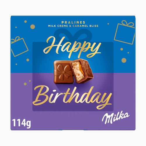 A square Milka chocolate pralines box with a blue and purple design and gold 'Happy Birthday' lettering, featuring two milk chocolate pralines on the front and '114g' in the lower left.