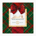 Lindt Karo Royal chocolate pralines box with a large red bow, set against a green and red tartan plaid background.