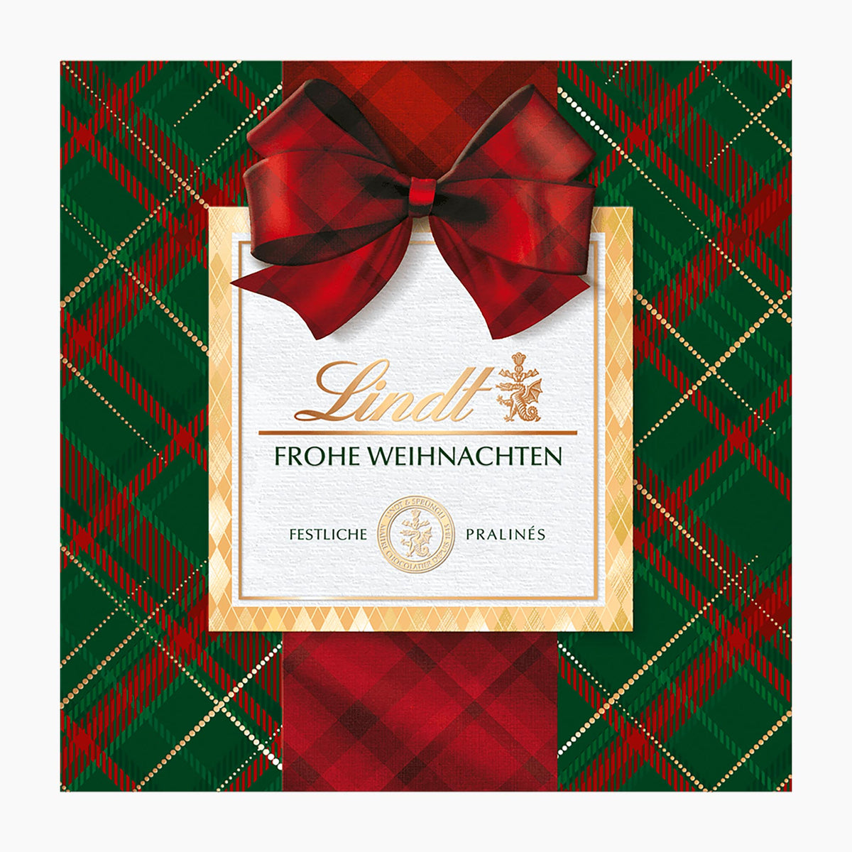 Lindt Karo Royal chocolate pralines box with a large red bow, set against a green and red tartan plaid background.
