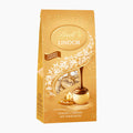 A 100g package of Lindt Lindor Golden Caramel chocolate pralines, featuring a golden-brown bag with white floral illustrations and a depiction of a chocolate piece with a nut.