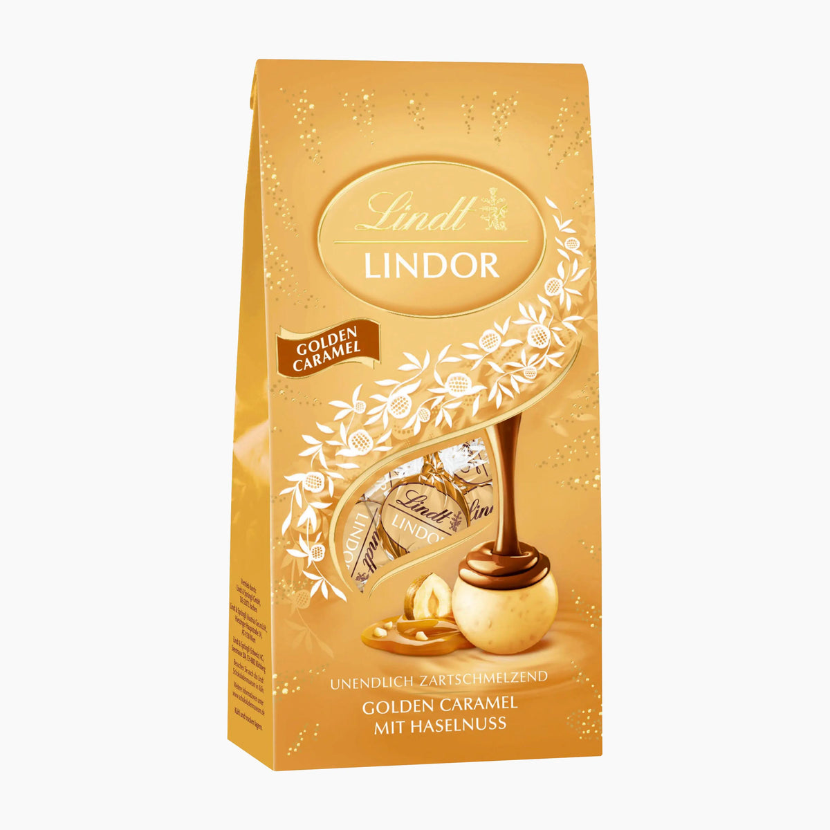 A 100g package of Lindt Lindor Golden Caramel chocolate pralines, featuring a golden-brown bag with white floral illustrations and a depiction of a chocolate piece with a nut.