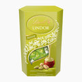 A 200g box of Lindt Lindor Pistachio milk chocolate pralines featuring illustrations of pistachios, and white leafy accents, set against a plain white background.