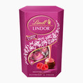 A 200g box of Lindt Lindor Raspberry & Cream chocolate pralines, featuring a vibrant magenta-purple packaging with gold and white branding, a clear window showing wrapped chocolates, and illustrations of raspberries and a chocolate praline.