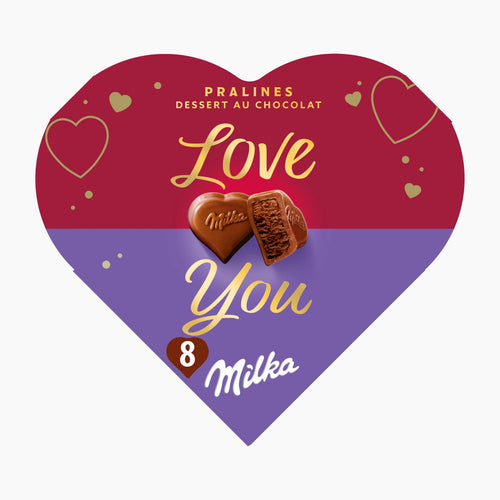 A heart-shaped Milka chocolate pralines box with a red top half and purple bottom half, decorated with gold heart outlines and the words 'Love You' in gold script. Two Milka milk chocolate pralines are shown in the center, with '8 Milka' printed near the bottom.